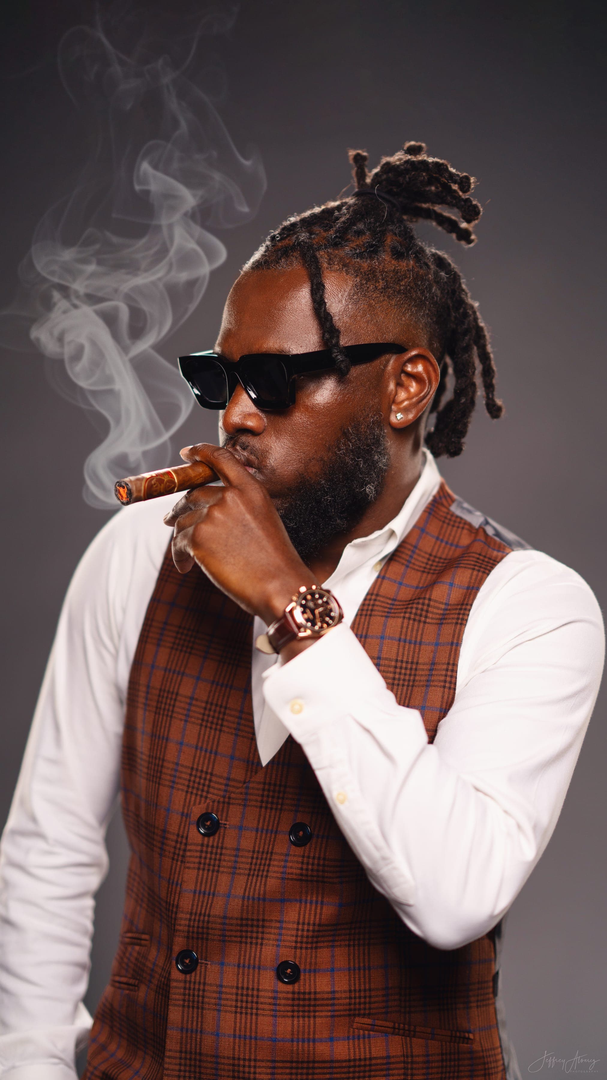 Lo $teve in a rust plaid three-piece suit, cigar in hand, at a New Orleans studio session